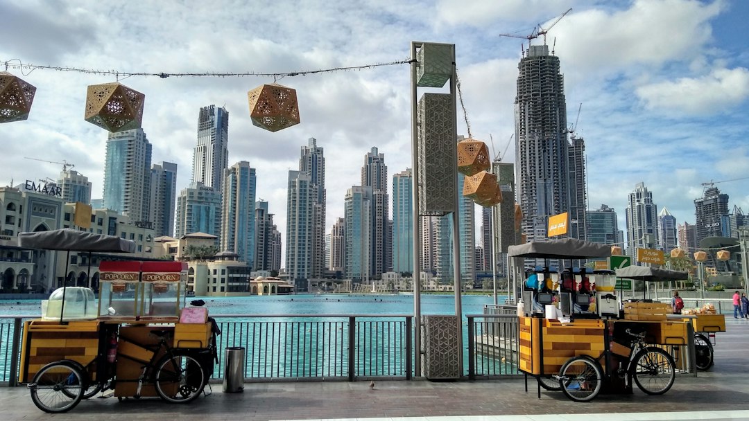 Street food carts along Dubai Mall waterfront promenade with Downtown Dubai skyscrapers and Emaar district in the background