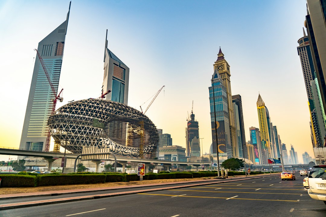 Museum of the Future under construction on Sheikh Zayed Road, Dubai, with Emirates Towers and city skyscrapers at dusk